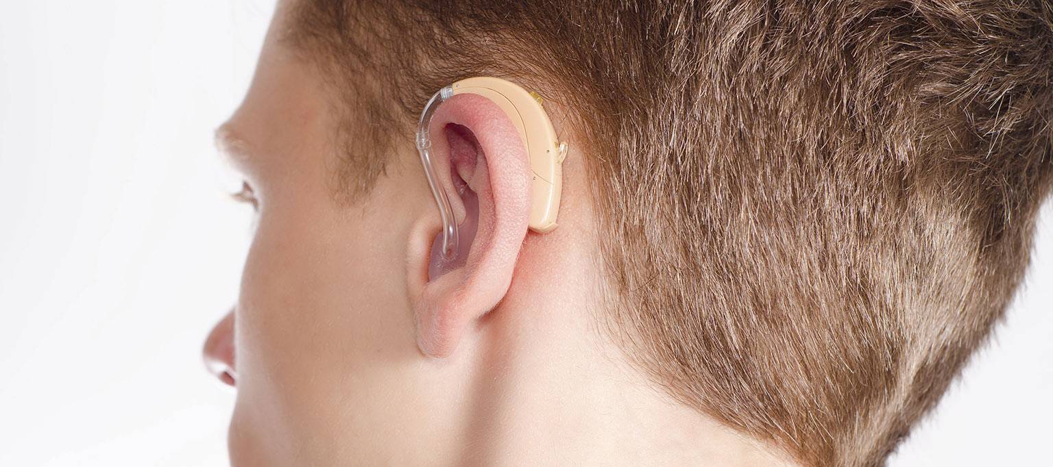 back of teenage boy head to show hearing aid