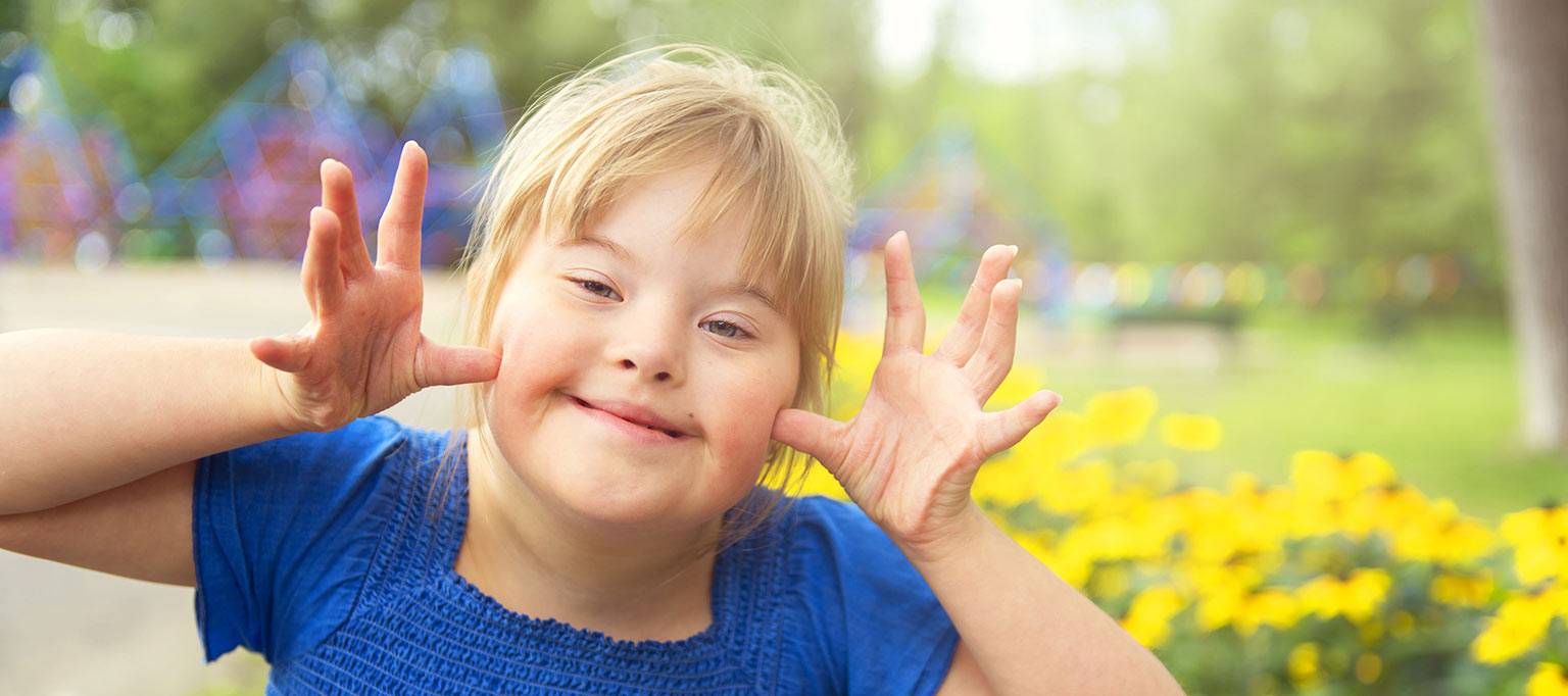 happy down syndrome girl outside making fun