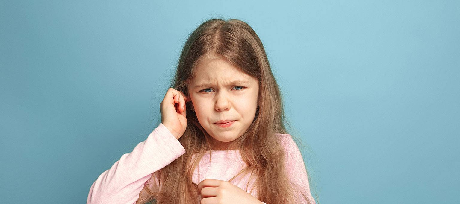 young girl holding ear in discomfort
