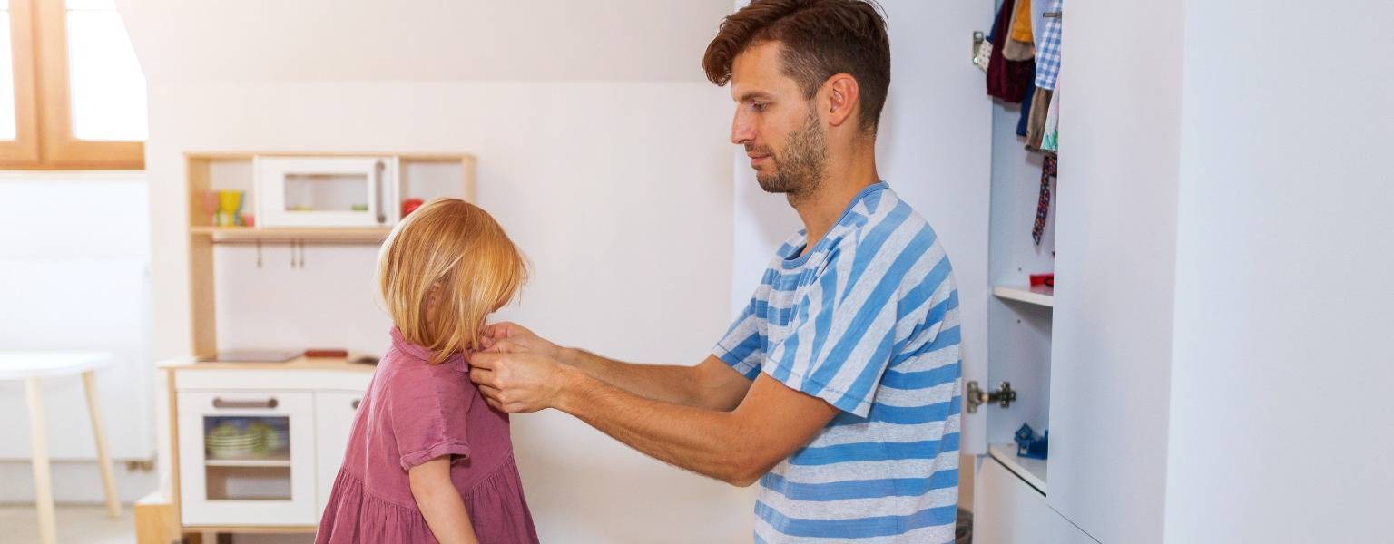 Young girl getting help to get dressed