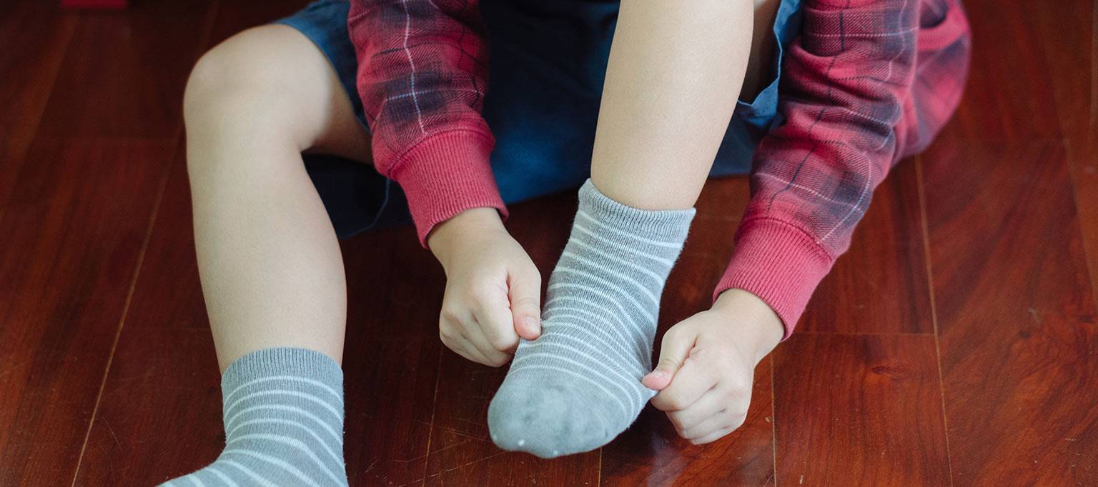 close up of boy putting on sock