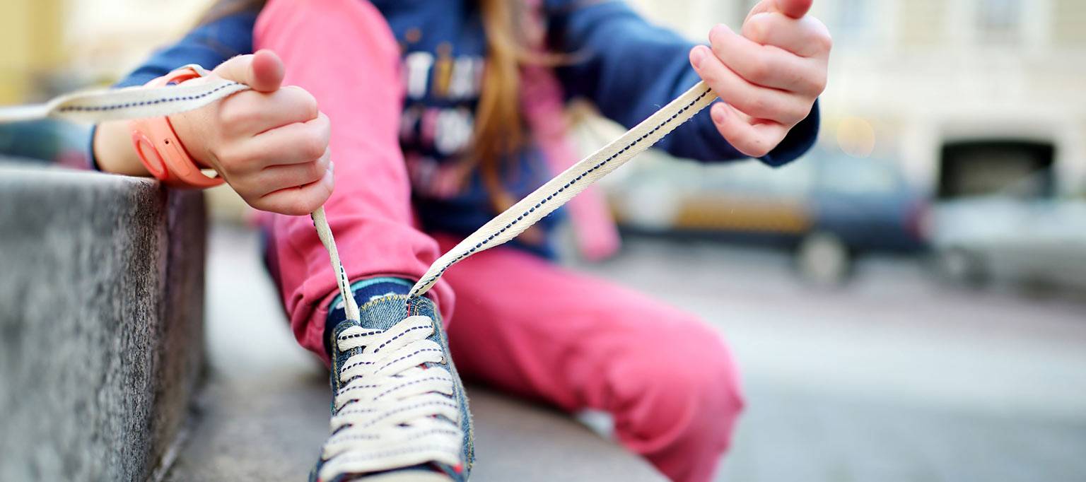 close up of girl tying shoelace